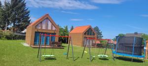 a group of playground equipment in front of a house at Apartamenty Drewniaki in Rydzewo