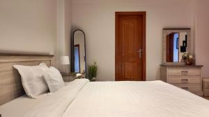 a bedroom with a large white bed and a mirror at Sada Compound (Women Only) سيدات فقط in Riyadh