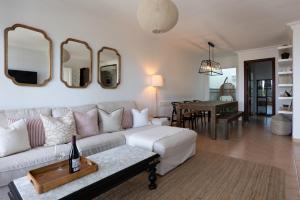 a living room with a white couch and mirrors on the wall at La Casa Nostra - family oriented house in quiet area in Bajamar