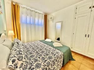 a bedroom with a bed with a green and white blanket at Casa Relu Urbanización Torres del Castillo in Costa de Antigua