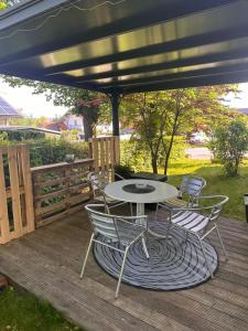 een terras met een tafel en stoelen op een dek bij Apartment Rosi SECONDO in Reisbach