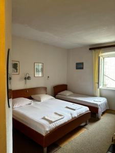 ein Schlafzimmer mit zwei Betten und einem Fenster in der Unterkunft Accommodation Old Town Vitaic in Korčula