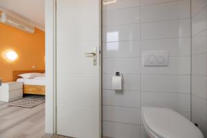 un bagno con doccia, servizi igienici e letto di Guesthouse Halilagic a Krk