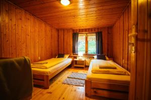 1 dormitorio con 2 camas en una habitación de madera en Dom na Szlaku en Wisła