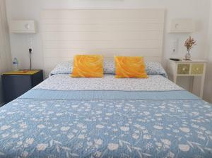 - un lit avec 2 oreillers orange dans l'établissement Hostal Mi Campaña, à Dénia