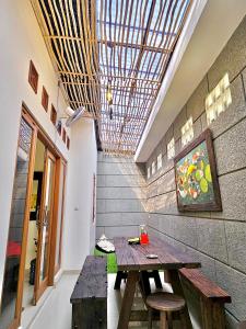 a dining room with a wooden table and benches at Omah Tabon Jogja - Dekat Dengan Malioboro in Timuran