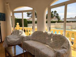 un soggiorno con divano e tavolo in vetro di Laura a Els Poblets