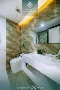 een badkamer met een wastafel, een toilet en een spiegel bij Merci Hotel & Apartment - Le Hong Phong, Hai Phong in Hai Phong