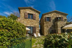 een stenen huis met twee ramen en een hek bij Casale In Vigna, CinqueTerreCoast in Casarza Ligure