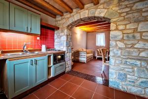 a kitchen with a stone wall and a sink at Taleton Eco Guesthouse in Xirokámbion