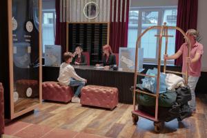 a little boy sitting on a chair in a waiting room at Sporthotel Igls in Innsbruck +123 photos