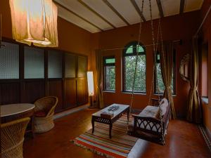 a living room with a swing and a table and chairs at The House of MG-A Heritage Hotel, Ahmedabad in Ahmedabad