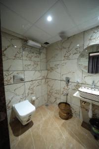 a bathroom with a toilet and a sink at N.M. Hotel in Mumbai +29 photos