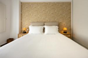モノリソスにあるFN Suitesのベッドルーム(白い大型ベッド、ランプ2つ付)