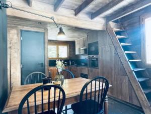 een keuken met een houten tafel en stoelen en een trap bij Le Chalet Georges in Chamonix-Mont-Blanc