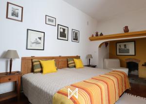 a bedroom with a large bed with yellow pillows at MyStay - A Casa do Visconde in Mértola