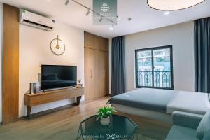een hotelkamer met een bed en een televisie bij Merci Hotel & Apartment - Le Hong Phong, Hai Phong in Hai Phong