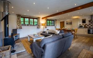 a living room with a couch and a stove at Oak Tree Cottage, Countryside Retreat with River View in Lydney