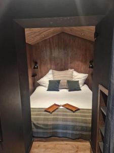 um quarto com uma cama com lençóis brancos e almofadas em Le Chalet Georges em Chamonix-Mont-Blanc