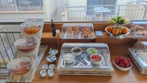 stół z kilkoma tacami żywności na balkonie w obiekcie Artemis Plaza w mieście Ajia Paraskiewi