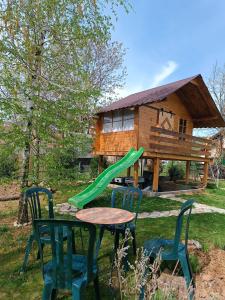 a table and chairs with a slide in front of a house at Nas San lower apartment in Vrdnik +8 photos