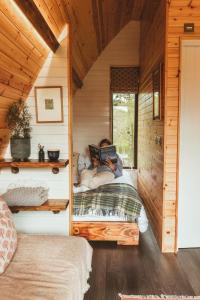 a bedroom with a bed in a wooden cabin at Tempo Manor Cabins in Tempo