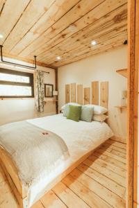 Cama grande en habitación con techo de madera en Tempo Manor Cabins, en Tempo