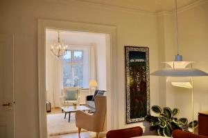 uma sala de estar com uma mesa e cadeiras e um espelho em Serviced Luxury Apartment in Østerbro - incl housekeeping once a week em Copenhague