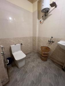 a bathroom with a toilet and a sink at Hotel Kaushambi Grand in Ghaziabad