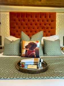a tray with a dog pillow and books on a bed at Quite Simply French in Lancaster