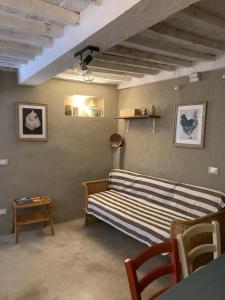 Cama en habitación con mesa y sofá en IL PICCINO 29, Esperienza Romantica in Borgo...., en Montescudaio