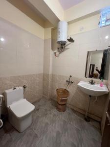 a bathroom with a toilet and a sink at Hotel Kaushambi Grand in Ghaziabad