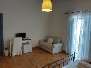ein Wohnzimmer mit Sofa und Schreibtisch in der Unterkunft Le Sette Perle in Malfa