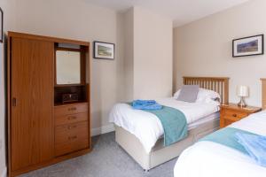 een slaapkamer met 2 bedden en een dressoir met een spiegel bij AIRE VUE - Skipton in Skipton