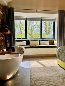 ein Wohnzimmer mit einem großen Fenster und einer Badewanne in der Unterkunft Quite Simply French in Lancaster