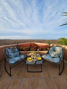 - une terrasse avec 2 chaises et une table dans l'établissement Wellness-Penthaus am Meer, à Palm-mar