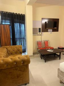 a living room with a couch and a coffee table at Hotel Kaushambi Grand in Ghaziabad