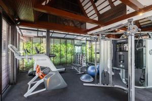 a gym with treadmills and machines in a building at Villa Akatsuki in Lipa Noi