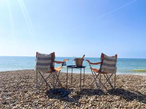 two chairs and a table on a beach at 15 Kingsway House in Worthing