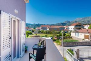 a balcony with a desk and a view of a house at Apartments Kiki in Mlini