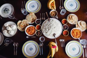 une table avec des assiettes de nourriture, des fourchettes et des cuillères dans l'établissement OYO KINGS HOTEL, à Katunayake