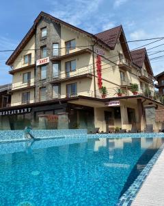 a large swimming pool in front of a hotel at Villa Anet in Bukovel