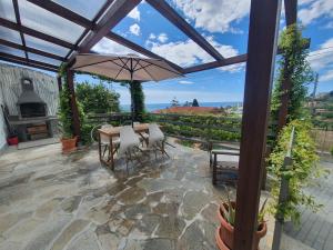a patio with a table and chairs and an umbrella at Residence Eucalyptus Suite 2 casa indipendente in Sanremo