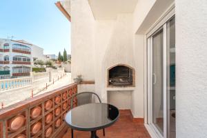 a balcony with a table and a pizza oven at WELCS CASA ADOSADA 144 EMP con piscina comunitaria in Montjoys