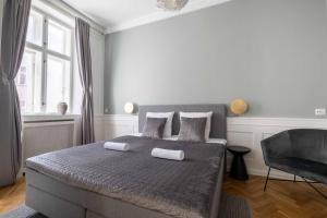 1 dormitorio con 1 cama con 2 almohadas y 1 silla en Lavish 4BR Flat in the Heart of CPH by The Canals, en Copenhague