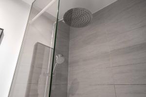 y baño con ducha y puerta de cristal. en Lavish 4BR Flat in the Heart of CPH by The Canals, en Copenhague