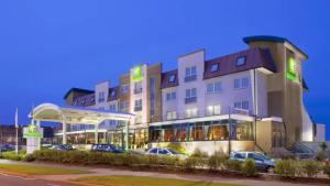 un hotel con coches aparcados frente a una gasolinera en Holiday Inn Aberdeen West, an IHG Hotel en Westhill 