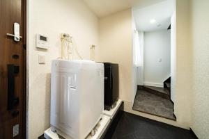 a bathroom with a refrigerator and a mirror at 84-5, Shiomi 301, Entire room for rent in Tokyo