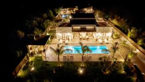 an aerial view of a building with a pool at night at White Stone Luxury Villa in Lithakia