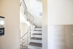 a spiral staircase in a building with white walls and white floors at FabEscape Panchkula Motels in Panchkula